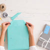 Woman wrapping a gift using a birthday gift sticker